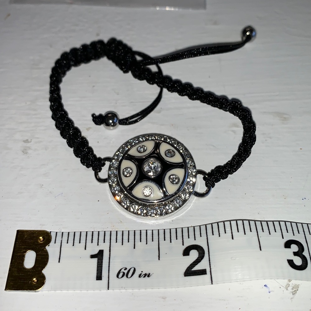 Adjustable braided black cord bracelet with one interchangeable snaps. NWOT